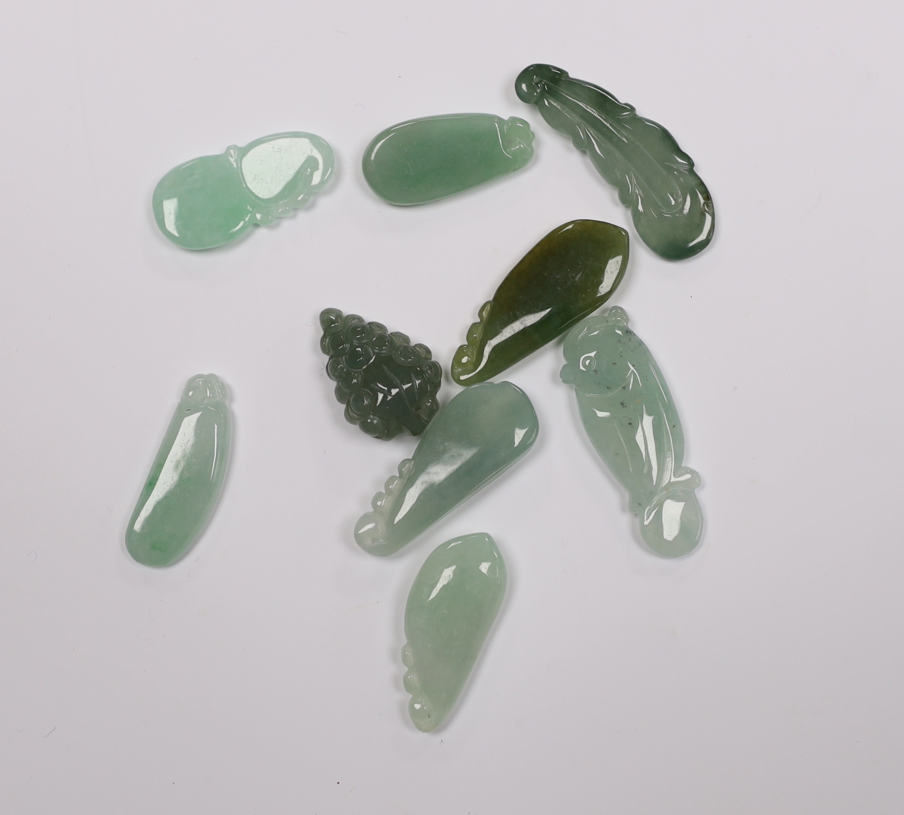 Ten various Chinese carved jadeite pendants
